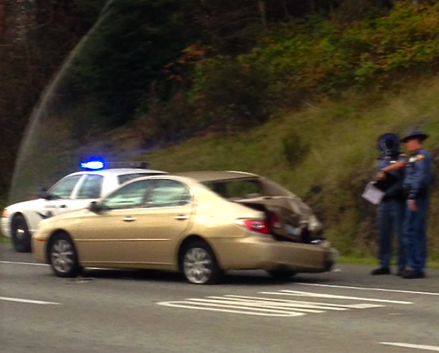 WSP trooper inspects collision damage to backend of car in 10/15/13 multi-vehicle accident